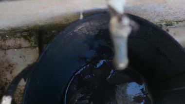 Lavabonun musluğundan bir damla su yavaş çekimde, musluğun yakınına düşer. Su yok, iklim değişikliği yok..