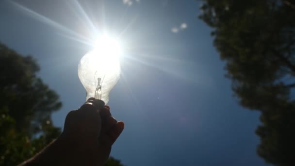 Электрическая Лампочка Удерживаемая Силуэтом Руки Человека Концепции Солнца Солнечная Энергия — стоковое видео