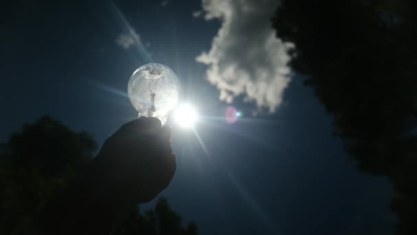 Електрична Лампочка Тримається Силуетом Руки Людини Сонці Концепція Сонячної Енергії — стокове відео