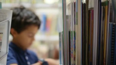 Anne ve Çocuklar Kitapçıda. Çocuklarının kitap seçmesine yardım eden bir anne.