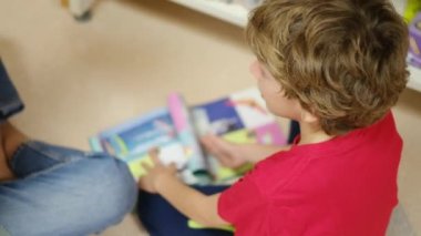 Anne ve Çocuklar Kitapçıda. Çocuklarının kitap seçmesine yardım eden bir anne.