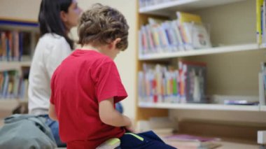 Anne ve Çocuklar Kitapçıda. Çocuklarının kitap seçmesine yardım eden bir anne.