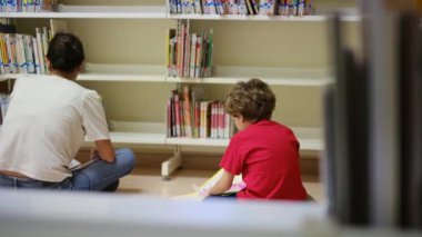 Anne ve Çocuklar Kitapçıda. Çocuklarının kitap seçmesine yardım eden bir anne.