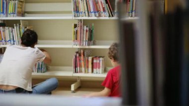 Anne ve Çocuklar Kitapçıda. Çocuklarının kitap seçmesine yardım eden bir anne.