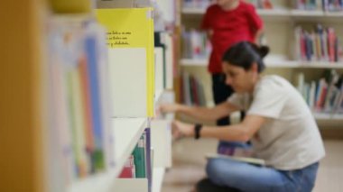 Anne ve Çocuklar Kitapçıda. Çocuklarının kitap seçmesine yardım eden bir anne.