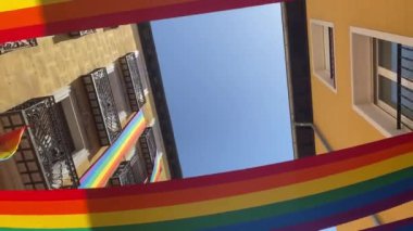 Gurur bayrağı rüzgarda dalgalanan gökkuşağı binalara monte edilmiş