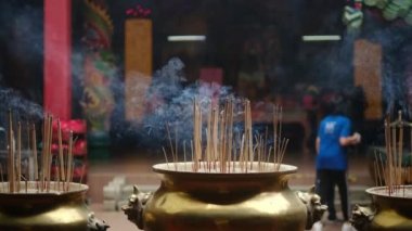 Tapınakta tütsü çubukları yakmak. Budist ve Hindu tapınaklarında geleneksel adak