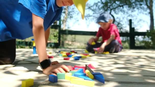 小男孩在户外玩耍 在公园里铺着生态彩色立方体的毯子 — 图库视频影像