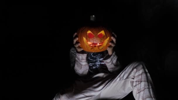 ライトが付いている彫刻されたハロウィーンのカボチャを保持する少年 — ストック動画