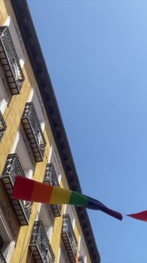 Gurur bayrağı rüzgarda dalgalanan gökkuşağı binalara monte edilmiş