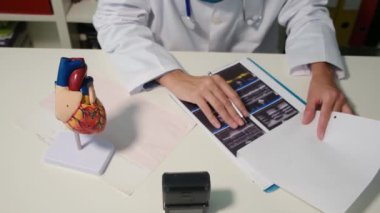 Hastanedeki masada oturan Müslüman kardiyolojistin yakın görüntüsü