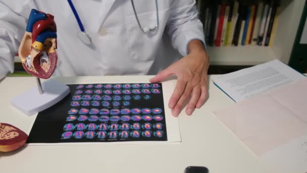 近距离观察坐在桌旁的心脏科医生 并解释住院期间的疾病 — 图库视频影像