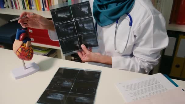 Detailní Pohled Muslimského Kardiologa Zobrazující Rentgeny Sedící Stolu Nemocnici — Stock video
