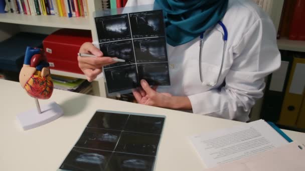 Vista Cerca Del Cardiólogo Musulmán Mostrando Rayos Sentados Mesa Hospital — Vídeo de stock