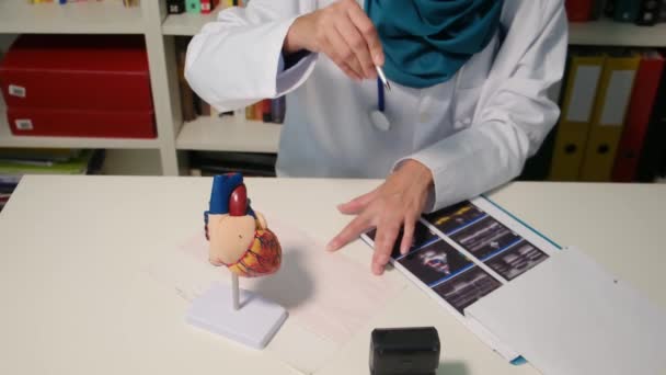 Nahaufnahme Eines Muslimischen Kardiologen Der Krankenhaus Tisch Sitzt — Stockvideo