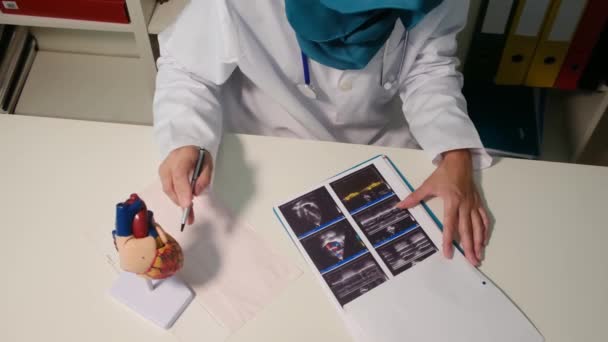Nahaufnahme Eines Muslimischen Kardiologen Der Krankenhaus Tisch Sitzt — Stockvideo