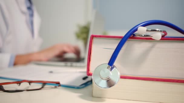 带着书桌的听诊器和带着笔记本电脑在医院工作的女医生的近景 — 图库视频影像