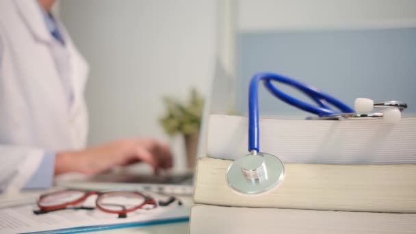 Nahaufnahme Des Stethoskops Mit Büchern Auf Dem Tisch Und Ärztin — Stockvideo