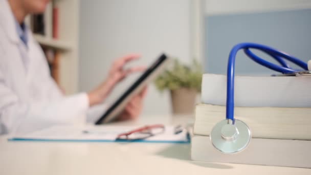 Zamknij Widok Stetoskopu Książkami Stole Lekarz Pomocą Tabletu Tle Szpitalu — Wideo stockowe