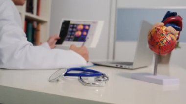 Hastanedeki masada oturan kardiyoloji uzmanının yakın görüntüsü.