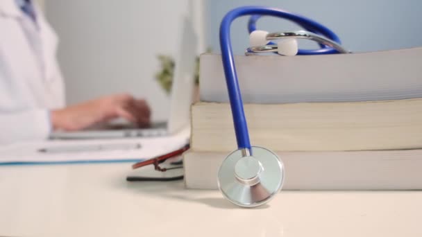 Nahaufnahme Des Stethoskops Mit Büchern Auf Dem Tisch Und Ärztin — Stockvideo