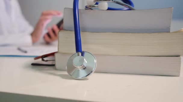 Zbliżenie Widok Stetoskop Książek Stole Lekarz Kobieta Pomocą Smartfona Tle — Wideo stockowe