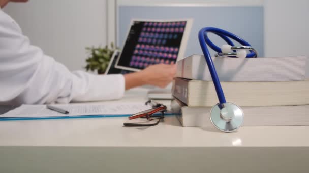 带着书桌的听诊器和在医院背景下工作的女医生的近景 — 图库视频影像