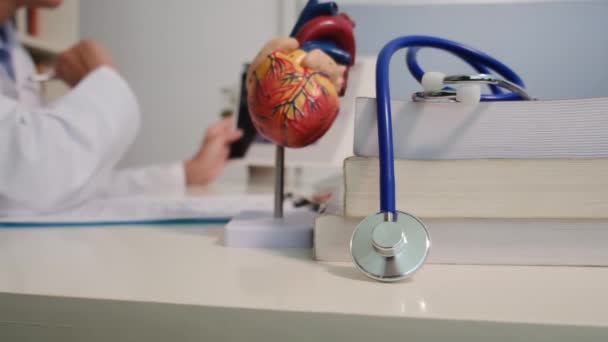 医院里坐在桌子旁边的心脏科医生近景 — 图库视频影像