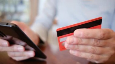 Akıllı telefon ve kredi kartı tutan ve evde online alışveriş yapan kadınları kapatın. Bankacılık, çevrimiçi alışveriş ve yaşam tarzı kavramı.