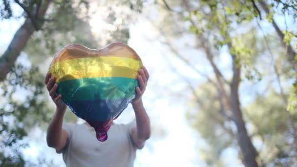 Ein Herzförmiger Luftballon Den Farben Der Lgbtq Flagge Gehalten Von — Stockvideo