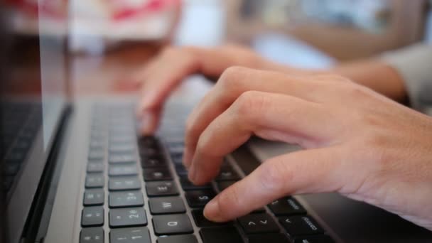 ノートパソコンのキーボード上の女性の手のテキストのクローズアップ — ストック動画