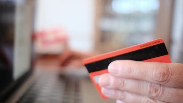 サイドビュー オンラインでクレジットカードで購入する若い女性の手 ラップトップを使用して自宅でオンライン取引を行う女性 — ストック動画
