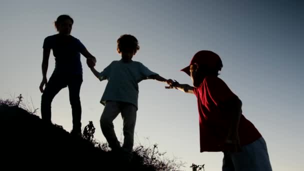 Bir Annenin Siluetleri Oğullarının Tepeye Tırmanmasına Yardım Ediyor — Stok video