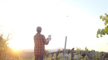 Genç çiftçi bir dron kullanarak ekin tarlasını inceler ve hasat analizi yapar. Çiftlik arazisinin haritasını çıkarmak ve keşfetmek. Çiftçilik ve tarım için yeni teknolojiler