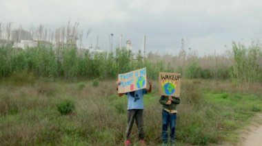 Çevre koruyucularının, iklim değişikliği hakkında gösteri yapan posterli çocukların görüntüleri