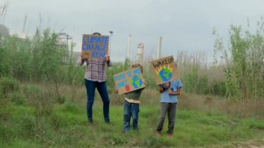 Çevre koruyucularının ailelerinin iklim değişikliği hakkında gösteriler yapan posterli görüntüleri