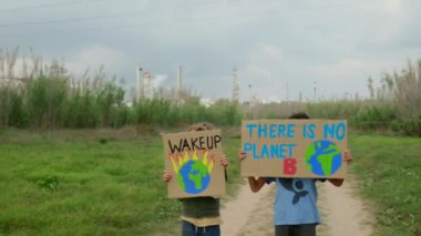 Çevre koruyucularının, iklim değişikliği hakkında gösteri yapan posterli çocukların görüntüleri