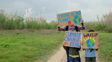 Çevre koruyucularının ailelerinin iklim değişikliği hakkında gösteriler yapan posterli görüntüleri