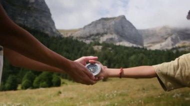 Anne ve çocuk dağlarda pusula tutuyor. 