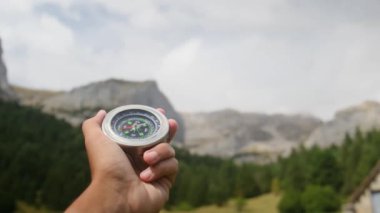 Dağlarda pusula tutan bir adam 