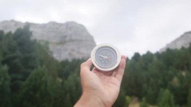 Dağlarda pusula tutan bir adam 