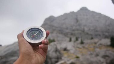 Dağlarda pusula tutan bir adam 