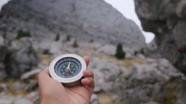 Dağlarda pusula tutan bir adam 