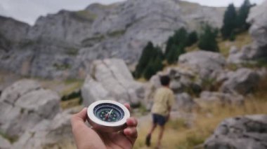 Dağlarda pusula tutan bir adam 