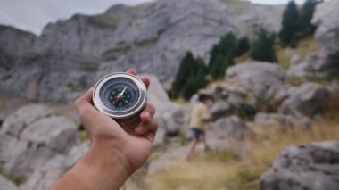 Dağlarda pusula tutan bir adam 