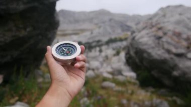 Dağlarda pusula tutan bir adam 