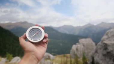 Dağlarda pusula tutan bir adam 