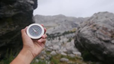 Dağlarda pusula tutan bir adam 