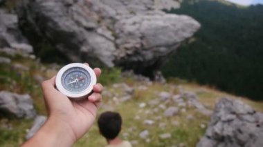 Dağlarda pusula tutan bir adam 