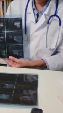 Steteskoplu genç bayan doktor ultrasonu inceliyor.